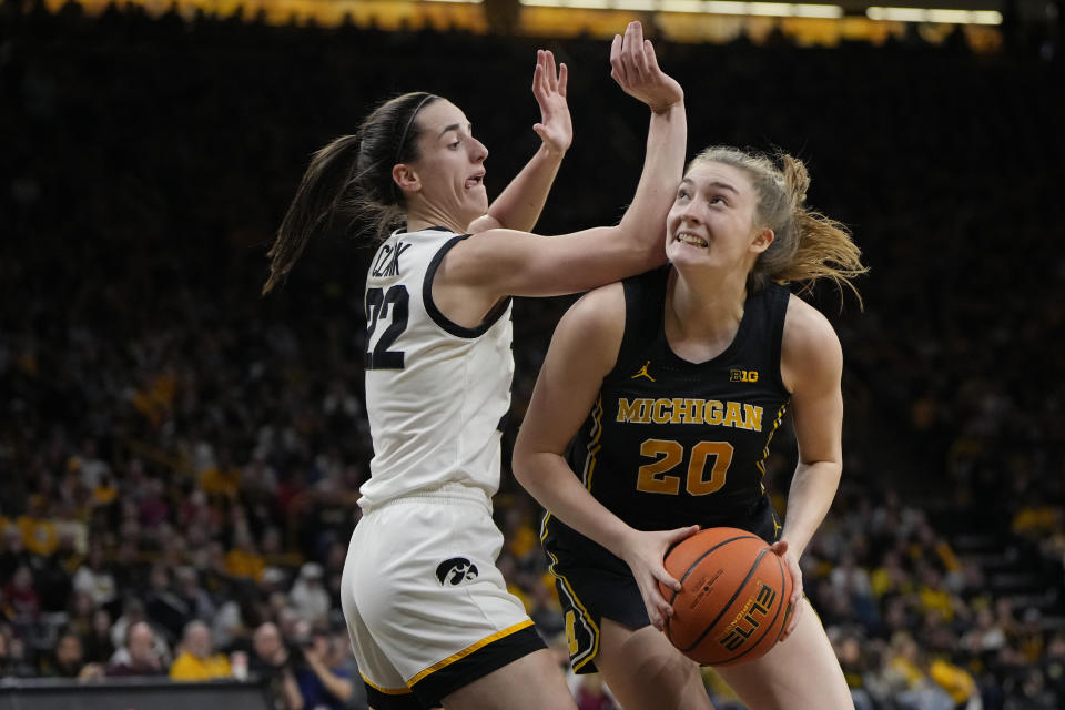 Iowa guard Caitlin Clark (22) defends against Michigan forward Alyssa Crockett (20) during the first half of an NCAA college basketball game Thursday, Feb. 15, 2024, in Iowa City, Iowa. (AP Photo/Matthew Putney)