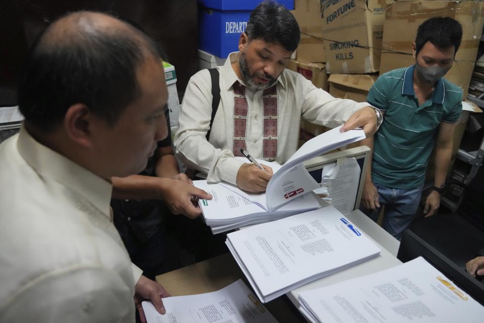 Filipino human rights lawyer Romel Bagares, center, and another lawyer representing Burmese complainants Gilbert Andres, left, files the criminal complaint against Myanmar's top generals at the Department of Justice in Manila, Philippines on Wednesday Oct. 25, 2023. Relatives of victims of alleged war crimes committed by Myanmar’s military filed a criminal complaint in the Philippines against their nation’s ruling generals in a desperate attempt to test whether such a case could succeed outside the violence-wracked country.(AP Photo/Aaron Favila)