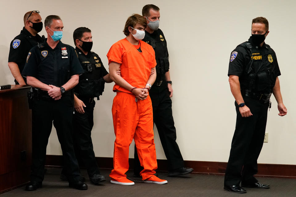 FILE - Payton Gendron is led into the courtroom for a hearing at Erie County Court, in Buffalo, N.Y., Thursday, May 19, 2022. Gendron was a 17-year-old high school senior in 2021 when he was investigated by New York’s State Police and ordered hospitalized for a mental health evaluation for typing into an economics class online program that his future plans included “murder-suicide.” But since he was a minor, he wasn’t covered under the state’s red flag law and it didn’t prevent him from later buying the high-powered rifle authorities say he used to kill 10 Black people in a racially-motivated shooting at Buffalo supermarket in May. (AP Photo/Matt Rourke, File)