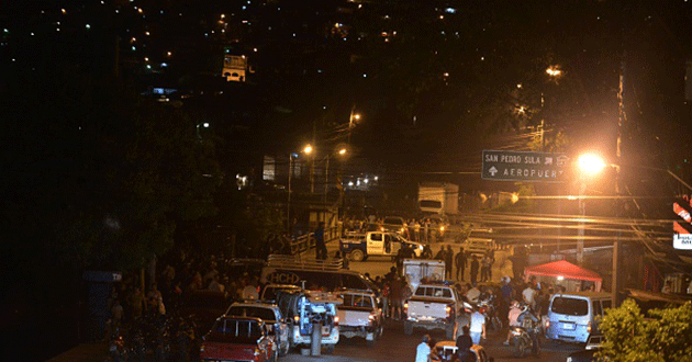 Police and media surround the area where five members of a family were killed in a Honduras neighbourhood earlier this week. Source: Getty