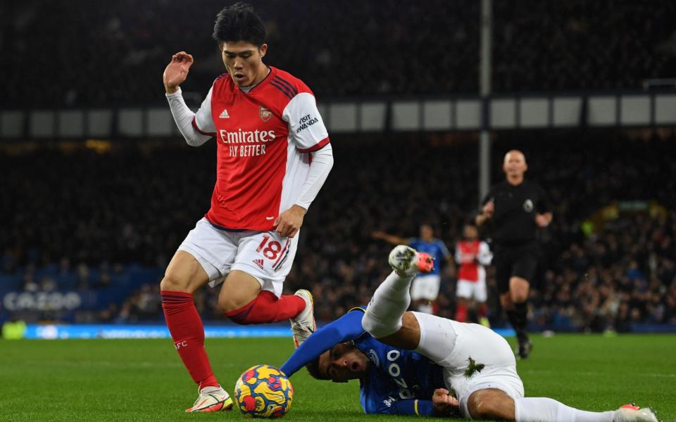 Arsenal's Japanese defender Takehiro Tomiyasu (L) vies with Everton's English midfielder Ben Godfrey  - AFP