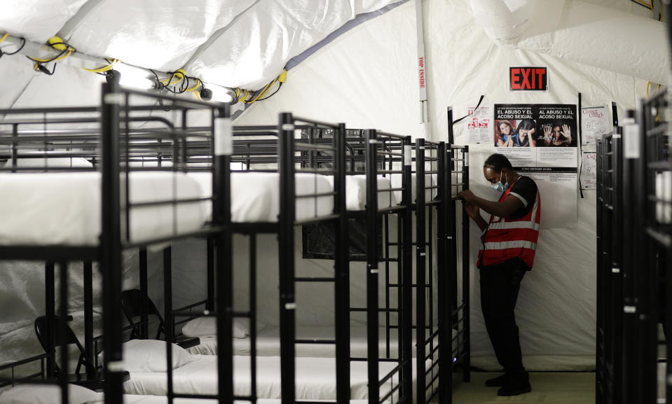 En esta fotografía del 9 de julio de 2019, un trabajador ajusta unas literas en el centro de detención para niños migrantes del gobierno de Estados Unidos en Carrizo Springs, Texas. (AP Foto/Eric Gay)