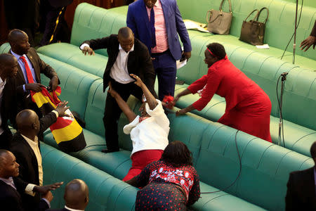 Ugandan opposition lawmakers fight with plain-clothes security personnel in the parliament while protesting a proposed age limit amendment bill debate to change the constitution for the extension of the president's rule, in Kampala, Uganda September 27, 2017. REUTERS/James Akena