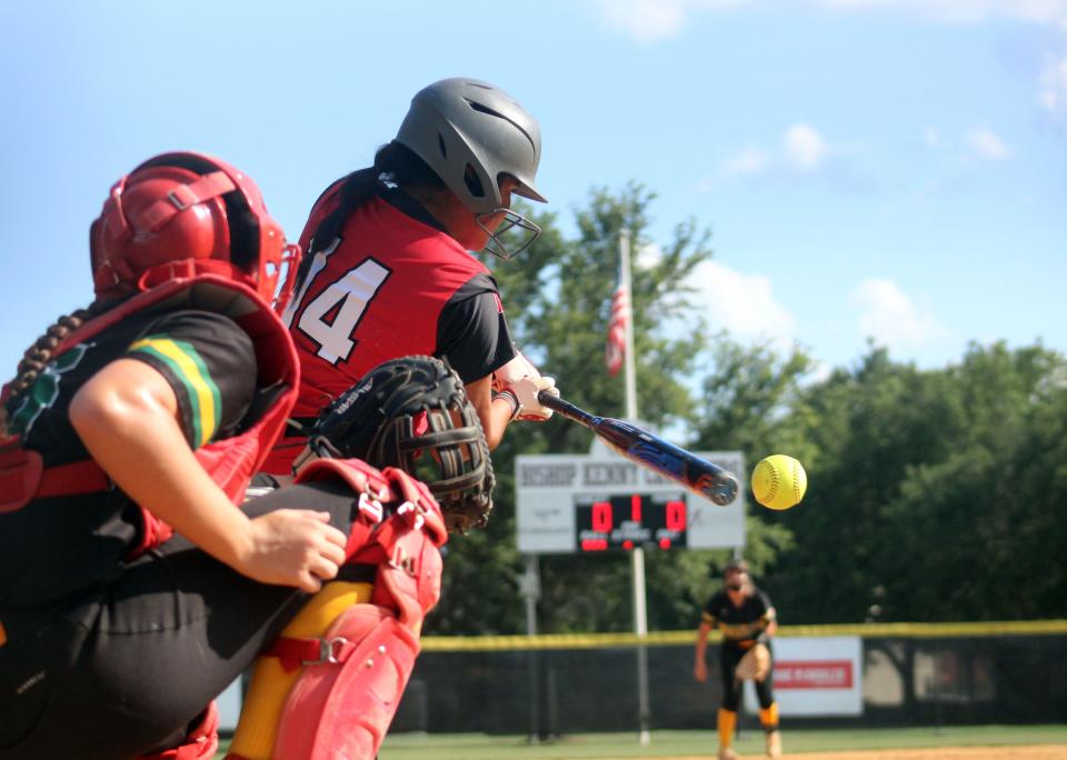 Bishop Kenny's Alleana De Leon hits a pitch during the District 3-4A Florida High School Athletic Association softball championship on May 5, 2022.  Yulee catcher Annelisa Winebarger is behind the plate. [Clayton Freeman/Florida Times-Union]