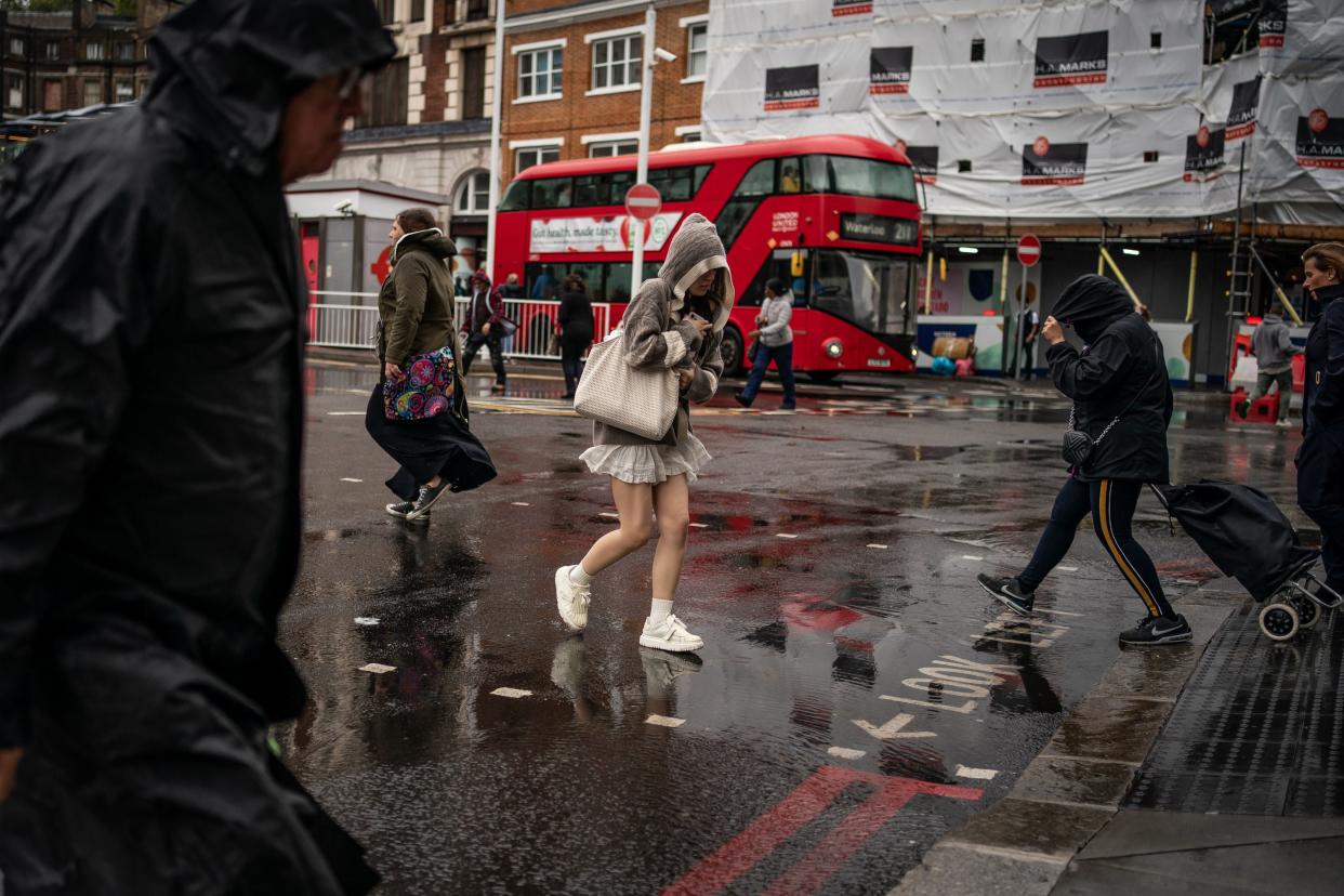 People walk through wet weather in Victoria, London. (PA)