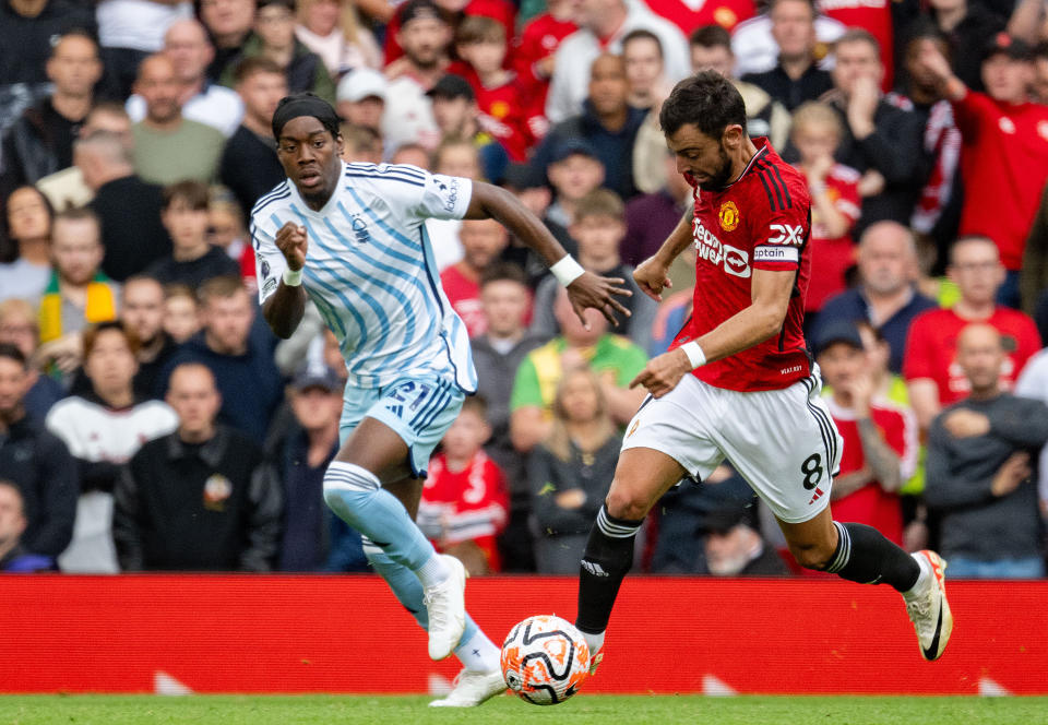 MANCHESTER, ENGLAND - AUGUST 26: Bruno Fernandes of Manchester United challenges for the ball with Anthony Elanga of Nottingham Forest during the Premier League match between Manchester United and Nottingham Forest at Old Trafford on August 26, 2023 in Manchester, England. (Photo by Ash Donelon/Manchester United via Getty Images)