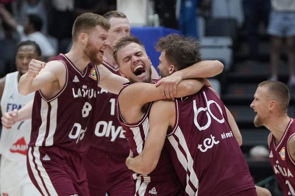 Latvia players celebrate after defeating France in their Basketball World Cup group H match at the Indonesia Arena stadium in Jakarta, Indonesia, Sunday, Aug. 27, 2023. (AP Photo/Achmad Ibrahim)