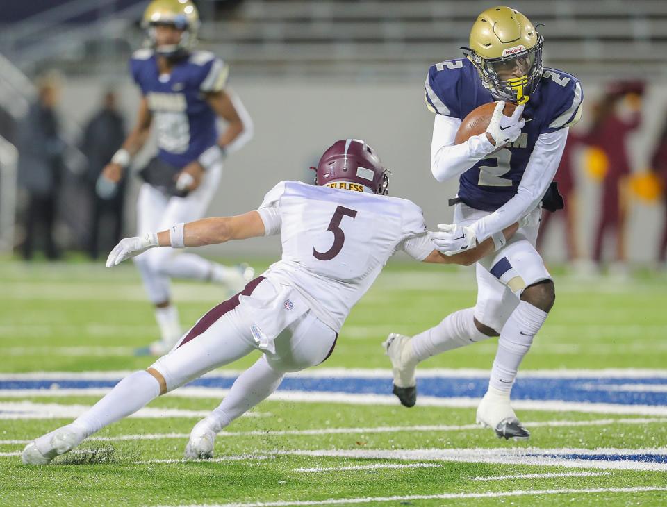 Hoban running back Xavier Williams brushes off a tackle by Walsh Jesuit's Aiden Henry in a Division II regional final Friday, Nov. 17, 2023.