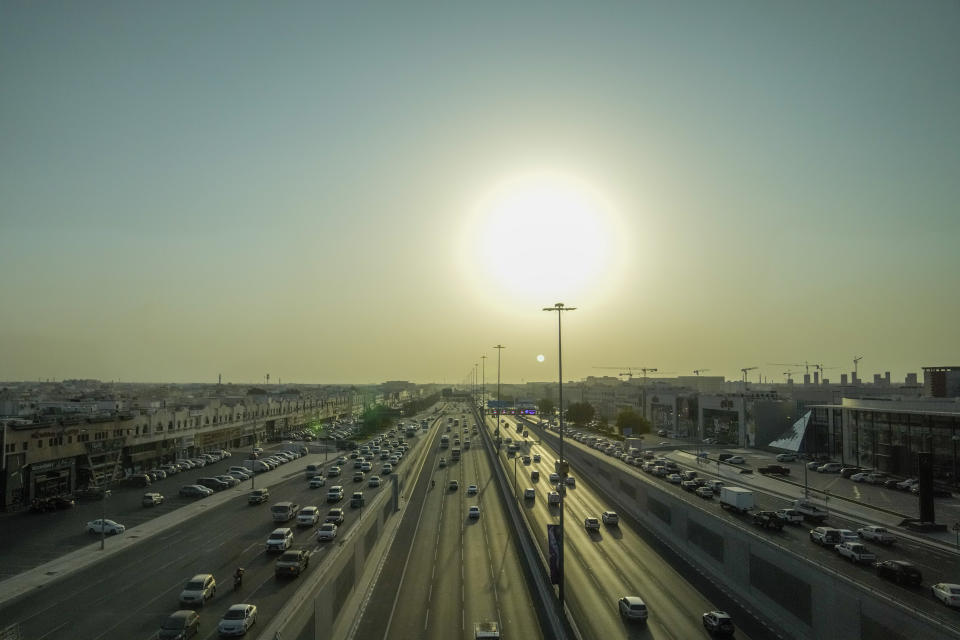 Cars drive at a highway as the sun sets in Doha, Qatar, Monday, Nov. 14, 2022. Qatar unveiled a plan last October to cut its emissions by a quarter by 2030. Then, Russia invaded Ukraine and made the Persian Gulf nation's liquid natural gas only more sought after. Demand for fossil fuels has brought immense wealth to Qatar, but in the coming decades, it could also make one of the world's hottest places unlivable. (AP Photo/Hassan Ammar)