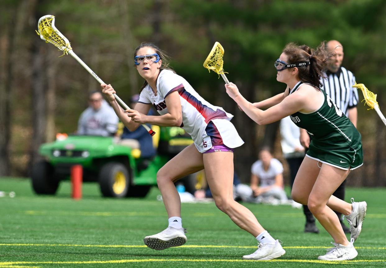 Lincoln-Sudbury junior Ella Ryan looks to pass the ball while pressured by Westwood junior Kate Sullivan during a girls lacrosse game at Lincoln-Sudbury High School, Friday, April 19, 2024.