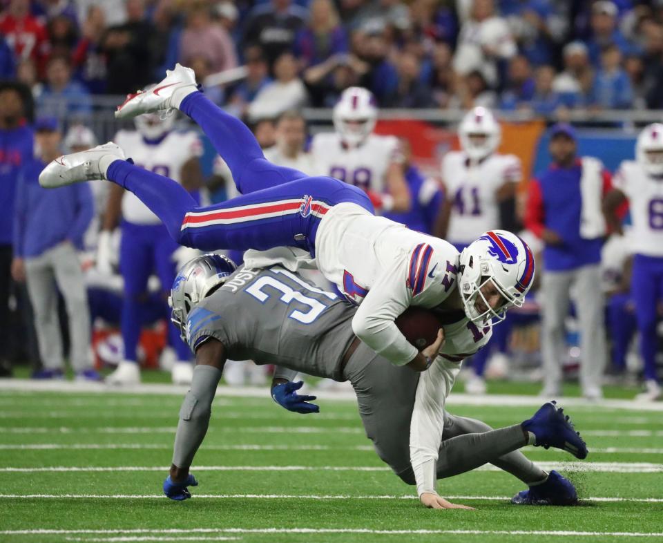 Lions safety Kerby Joseph (31) tackles Bills quarterback Josh Allen.