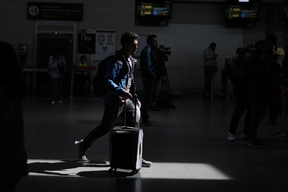 A passenger walks past the check-in counter of the low-cost airline after it suspended its operations at the El Dorado International Airport in Bogota, Colombia, Tuesday, Feb. 28, 2023. The airline is awaiting the completion of an integration process with a group of airlines that must be approved by the Colombian authorities. (AP Photo/Fernando Vergara)