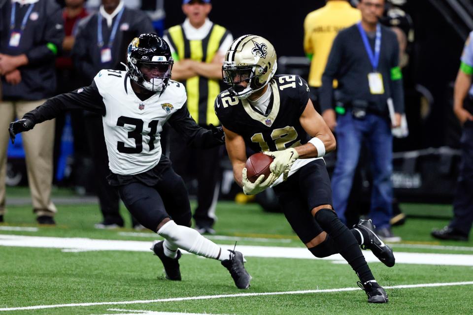 New Orleans Saints wide receiver Chris Olave (12) makes a move to get past Jacksonville Jaguars cornerback Darious Williams (31) after a reception in the second half of an NFL football game in New Orleans, Thursday, Oct. 19, 2023. (AP Photo/Butch Dill)