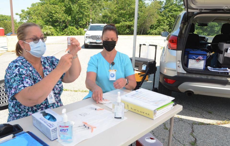 Susan Dubb, RN, BS, left, prepares a Moderna COVID-19 vaccine shot next to Jennifer Ceccarelli RN, BSN Monday at a drive-up Uncas Health District Mobile Vaccination Team Monday near the food distribution off Route 2 in Norwich. [John Shishmanian/ NorwichBulletin.com]