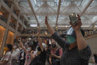 Protesters gesture with five fingers, signifying the "Five demands - not one less" in a shopping mall during a protest against China's national security legislation for the city, in Hong Kong, Monday, June 1, 2020. The mouthpiece of China's ruling Communist Party says U.S. moves to end some trading privileges extended to Hong Kong grossly interfere in China's internal affairs and are doomed to fail. (AP Photo/Vincent Yu)