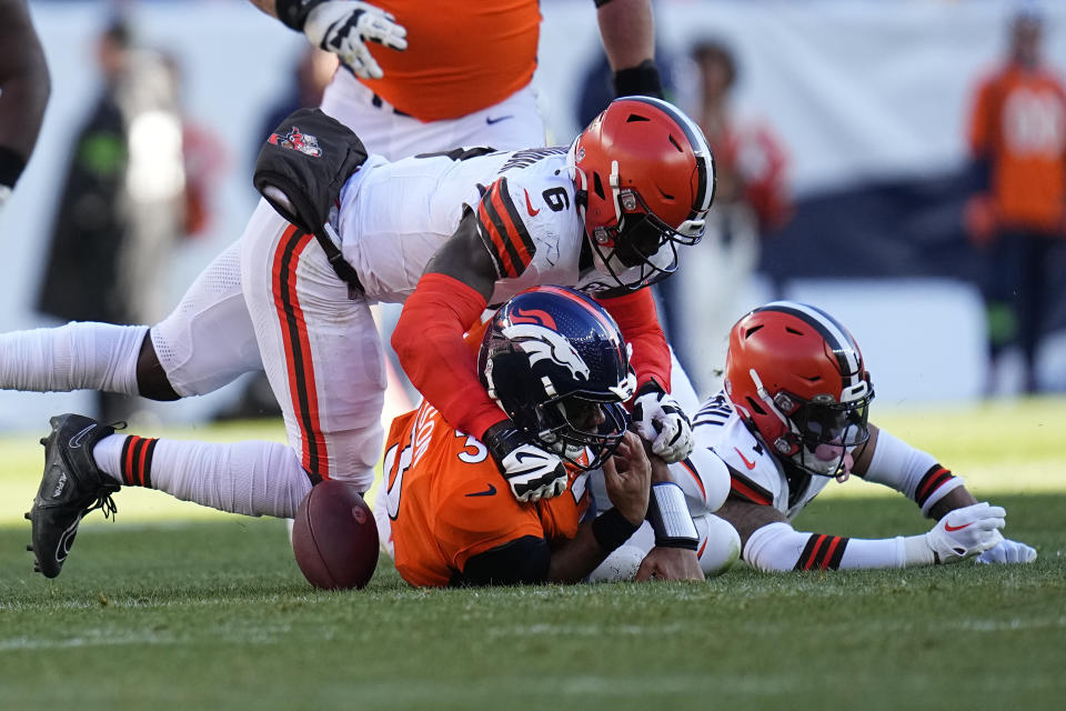 Denver Broncos quarterback Russell Wilson (3) fumbles as Cleveland Browns linebacker Jeremiah Owusu-Koramoah (6) defends during the first half of an NFL football game on Sunday, Nov. 26, 2023, in Denver. (AP Photo/Jack Dempsey)