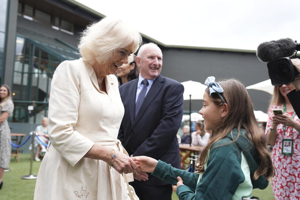 Queen Camilla speaks to Camila, daughter of Mexican tennis player Santiago Gonzalez, during a visit to the All England Lawn Tennis and Croquet Club in Wimbledon, south west London, on day ten of the 2024 Wimbledon Championships, Wednesday July 10, 2024. (Jordan Pettitt/Pool photo via AP)