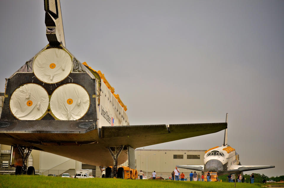 Space Shuttle Endeavour (R), leaving the Orbiter Processing Facility on its way to the Vehicle Assembly Building (VAB), passes Space Shuttle Discovery at Kennedy Space Center August 11, 2011 in Cape Canaveral, Florida. Space Shuttles Endeavour and Discovery switched buildings as they are being decommissioned with the end of the Shuttle program. (Photo by Roberto Gonzalez/Getty Images)