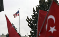 Members of a Turkish political party hold national flags during a protest near the U.S. embassy in Ankara, Turkey, Tuesday, Oct. 8, 2019. Turkey's vice president Fuat Oktay says his country won't bow to threats in an apparent response to U.S. President Donald Trump's warning to Ankara about the scope of its planned military incursion into Syria. (AP Photo/Burhan Ozbilici)