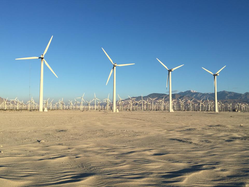 Wind turbines are visible along Indian Canyon Drive in Palm Springs. The road was closed Monday, April 22, after being covered in sand.