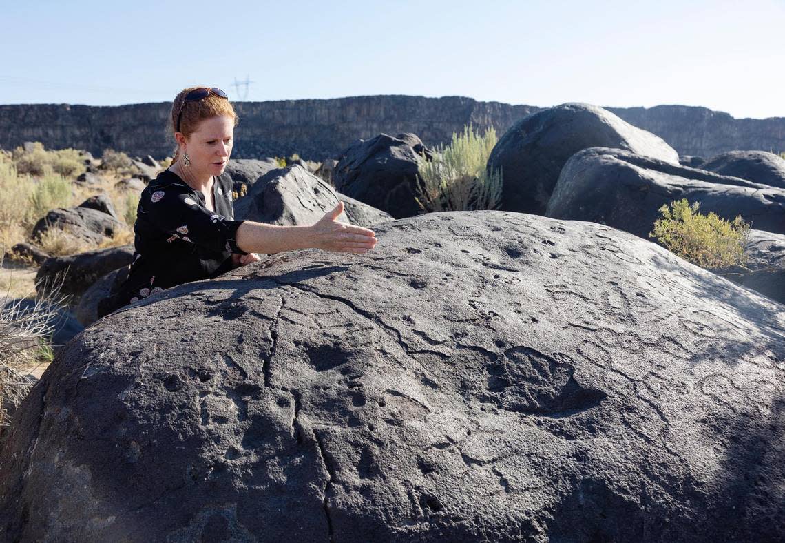 Archaeologist and director of Canyon County Parks Nicole Schwend points to a panel of petroglyph elements that were pecked into a basalt boulder thousands of years ago at present-day Celebration Park in Melba. Clusters of petroglyph art made by Native Americans can be found on the basalt rocks along the Snake River Canyon.