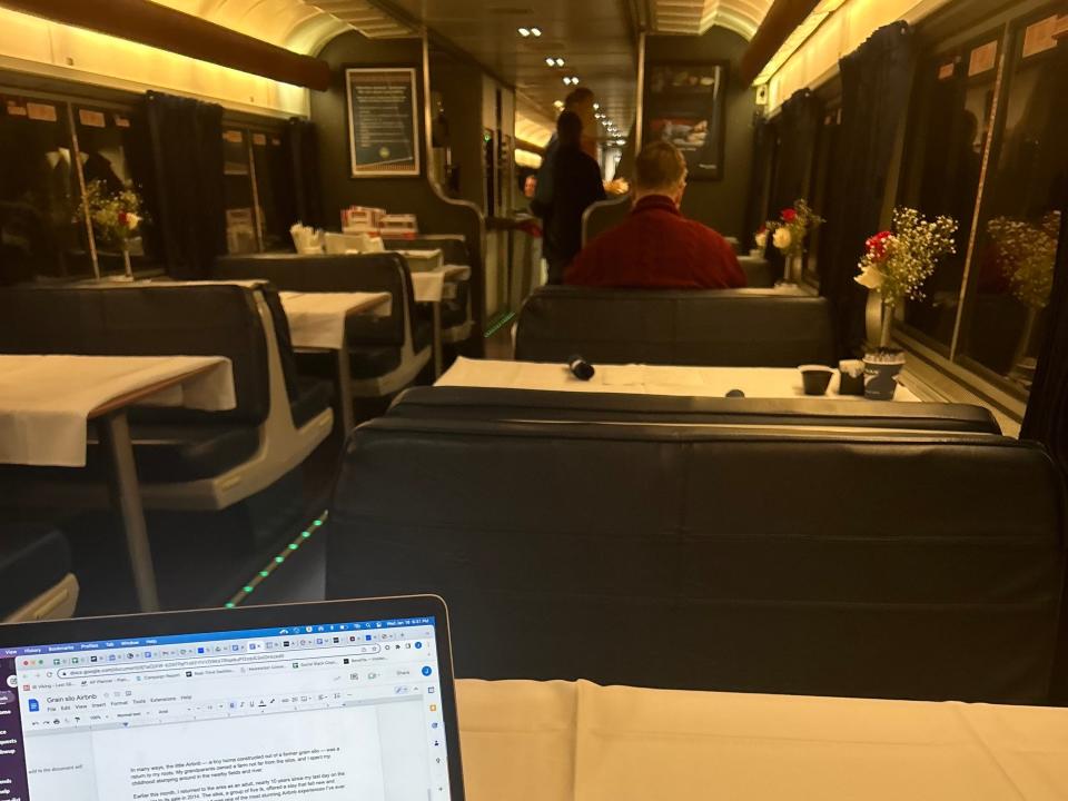 A photo of a laptop on a dining table in an Amtrak dining cart.