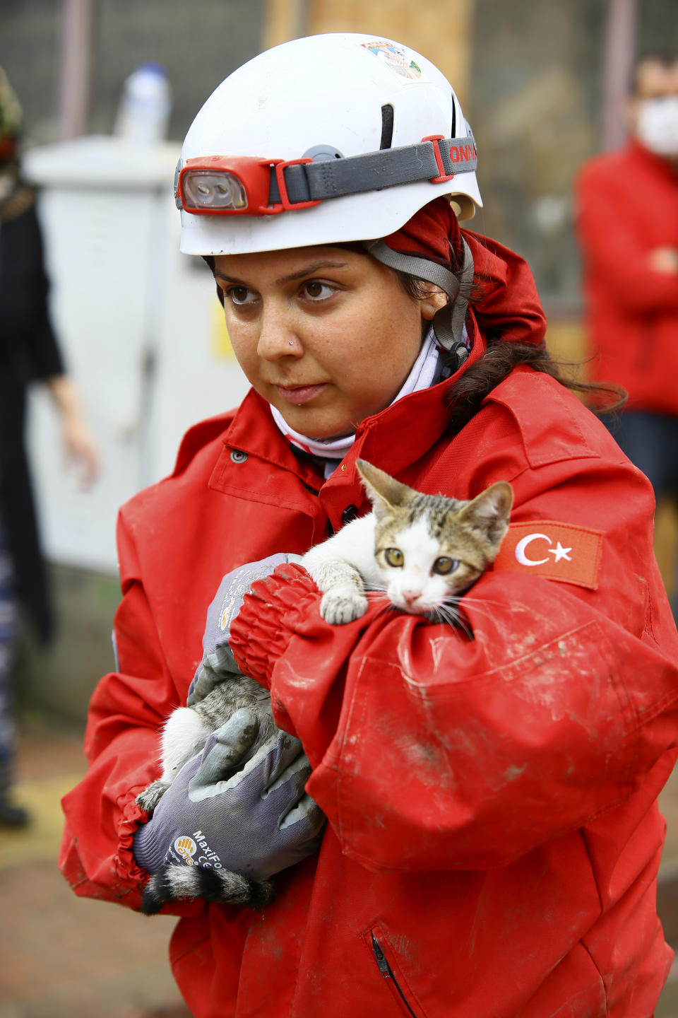 A rescue worker holds a kitten she saved from a building in Bozkurt town of Kastamonu province, Thursday, Aug. 12, 2021. The floods triggered by torrential rains battered the Black Sea coastal provinces of Bartin, Kastamonu, Sinop and Samsun on Wednesday, demolishing homes and bridges and sweeping cars away by torrents. Helicopters scrambled to rescue people stranded on rooftops.(IHA via AP)