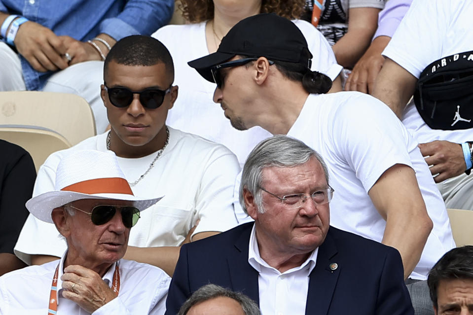 Swedish football player Zlatan Ibrahimovic, top right, speaks to French football player Kylian Mbappe as they wait for the start of the final match of the French Open tennis tournament between Serbia's Novak Djokovic and Norway's Casper Ruud at the Roland Garros stadium in Paris, Sunday, June 11, 2023. (AP Photo/Aurelien Morissard)