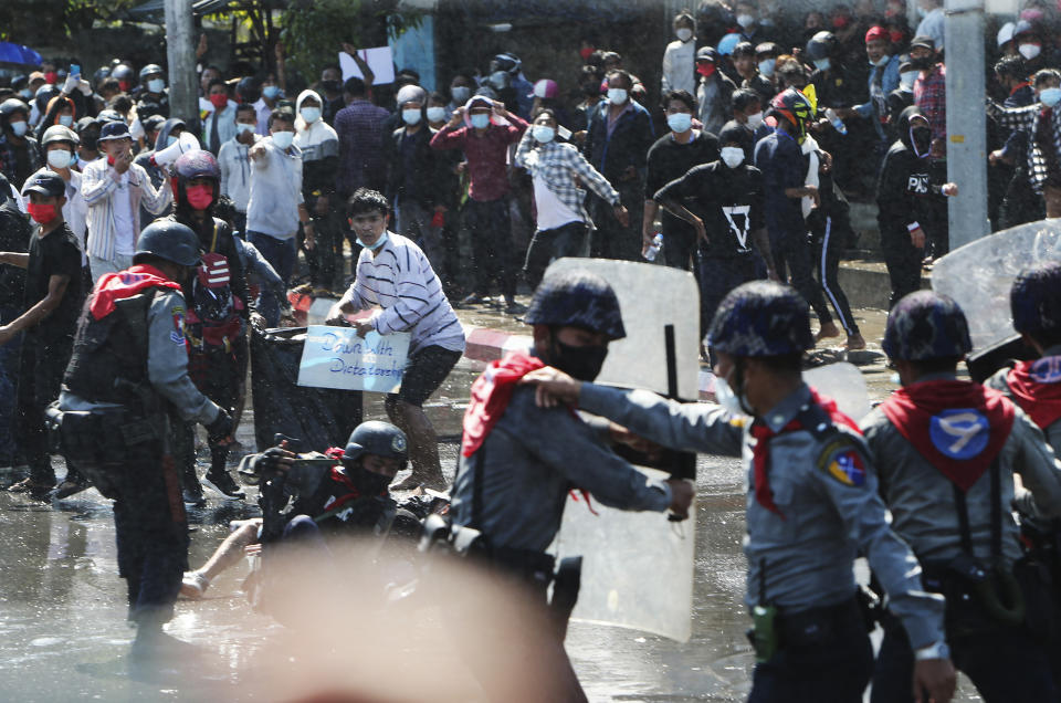 Protesters run after police fire warning-shots and use water cannons to disperse them during a protest in Mandalay, Myanmar on Tuesday, Feb. 9, 2021. Police cracked down Tuesday on the demonstrators protesting against Myanmar’s military takeover who took to the streets in defiance of new protest bans. (AP Photo)