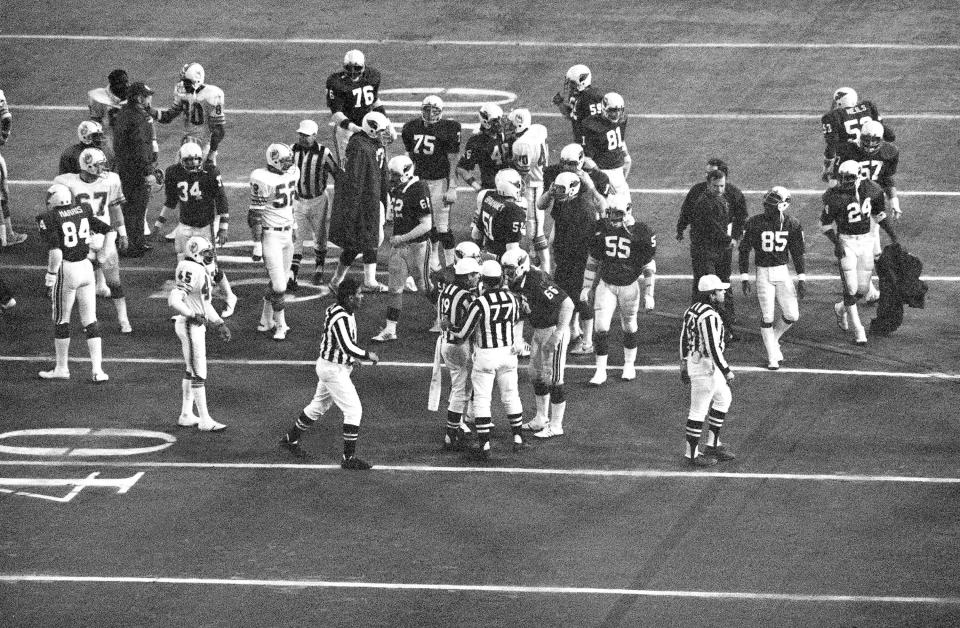 Dolphins and Cardinals players mill around following a fourth-quarter brawl on Thanksgiving Day 1977. Cardinals offensive lineman Conrad Dobler (66) was tossed from the game.