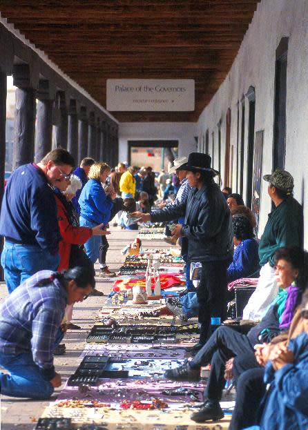 This undated image provided by the Santa Fe Convention and Visitors Bureau shows vendors at the Palace of the Governors in Santa Fe, N.M., selling jewelry, crafts and other wares. The Palace of the Governors, built in the 1600s as the seat of government for Spain's Southwestern territories, is now one of a half-dozen museums in Santa Fe devoted to history, culture and art. (AP Photo/Sante Fe Convention and Visitors Bureau, Chris Corrie)