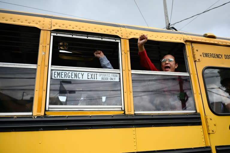 Released Nicaraguan political prisoners wave as they leave on a bus after their arrival at the Guatemala City Air Base on September 5, 2024. The United States said Thursday it had secured the release of 135 political prisoners from Nicaragua, the latest mass transfer by President Daniel Ortega's increasingly authoritarian government. (JOHAN ORDONEZ)