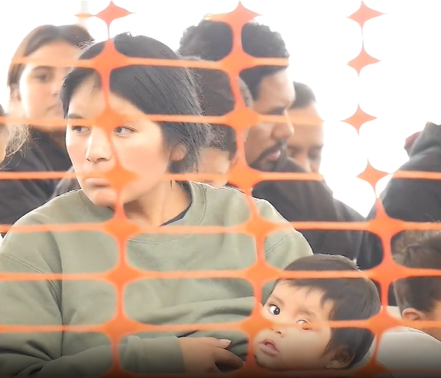 A migrant feeds her child while waiting for transportation at the Regional Center for Border Health in Somerton.