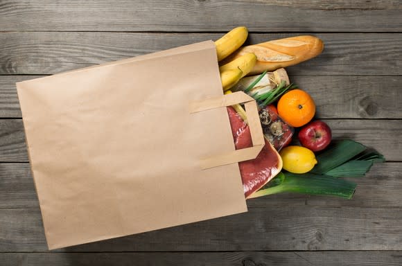 A grocery bag spilling its contents on a table.