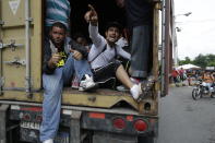 Honduran migrants making their way to the U.S. as a group, get a free ride in the back of a driver's trailer as they pass through Zacapa, Guatemala, Wednesday, Oct. 17, 2018. The group of some 2,000 Honduran migrants hit the road in Guatemala again Wednesday, hoping to reach the United States despite President Donald Trump's threat to cut off aid to Central American countries that don't stop them. (AP Photo/Moises Castillo)