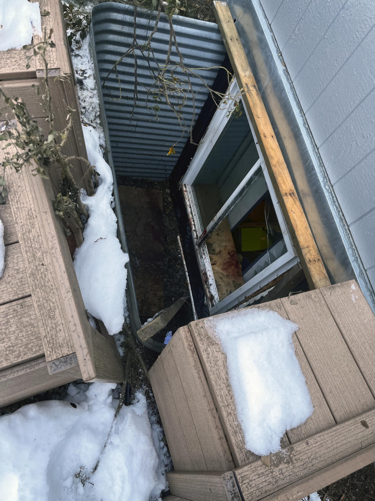 In this image provided by Central Emergency Services for the Kenai Peninsula Borough, a window well is shown Sunday, Nov. 20, 2022, through which a moose fell into a home in Soldotna, Alaska. The moose was tranquilized and removed from the house on a stretcher, revived and set free back into the wild. (Capt. Josh Thompson/Central Emergency Services via AP)