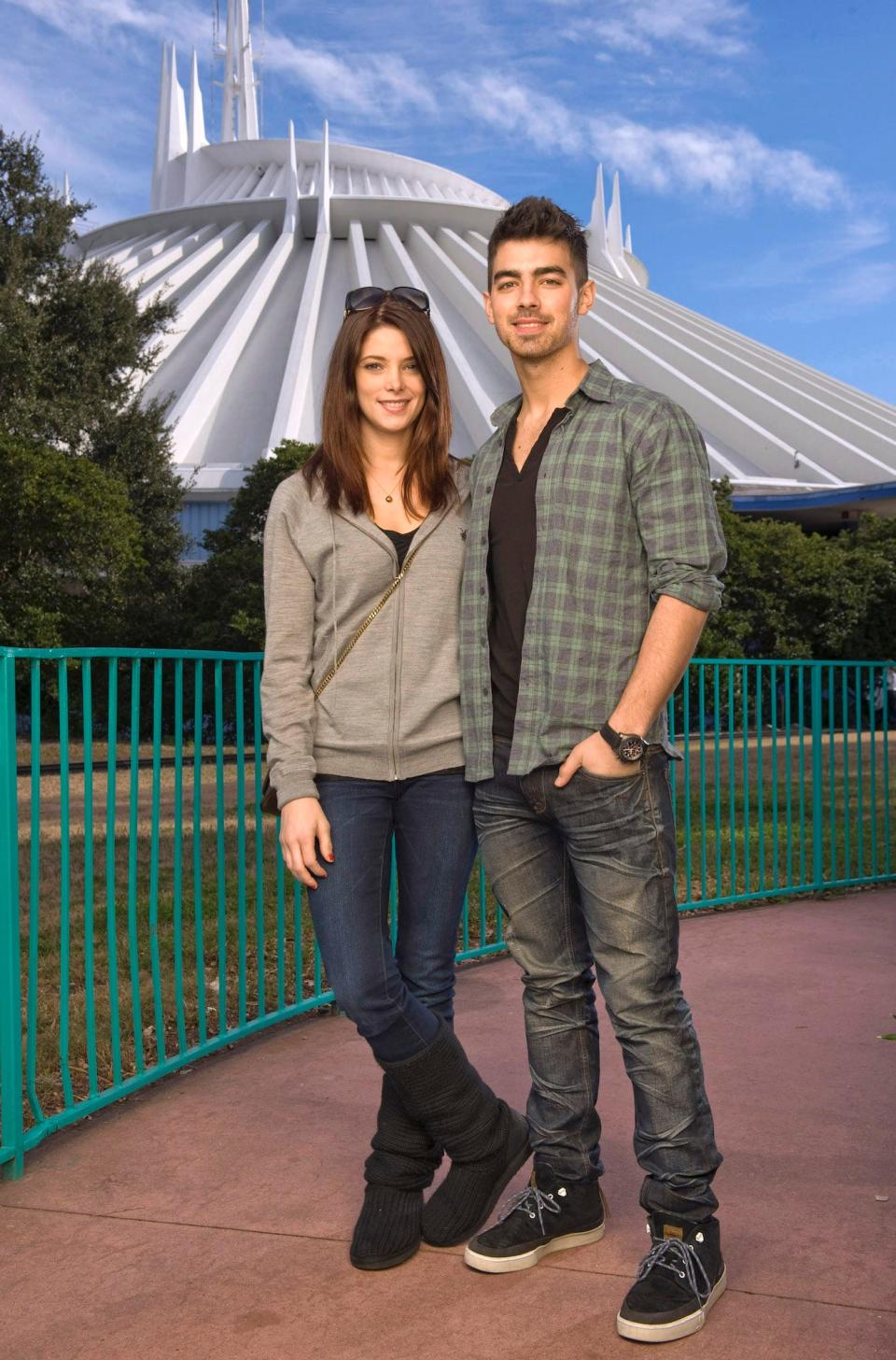 Ashley Greene and Joe Jonas stand in front of Disney World's Space Mountain ride.