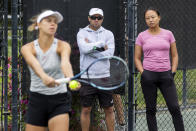 Lan Yao-Gallop and coach Mark Gellard, center, watch as Magda Linette prepares to serve on a practice court at the Charleston Open tennis tournament in Charleston, S.C., Monday, April 3, 2023. Yao-Gallop is a member of the women’s professional tennis tour’s Coach Inclusion Program to develop female coaches. (AP Photo/Mic Smith)