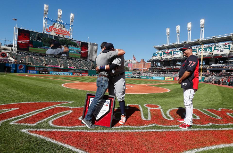 Indians president Chris Antonetti, left, embraces Tigers designated hitter Victor Martinez after presenting him with a plaque as Indians manager Terry Francona looks on before the start of the game against the Tigers on Saturday, Sept.15, 2018, in Cleveland.