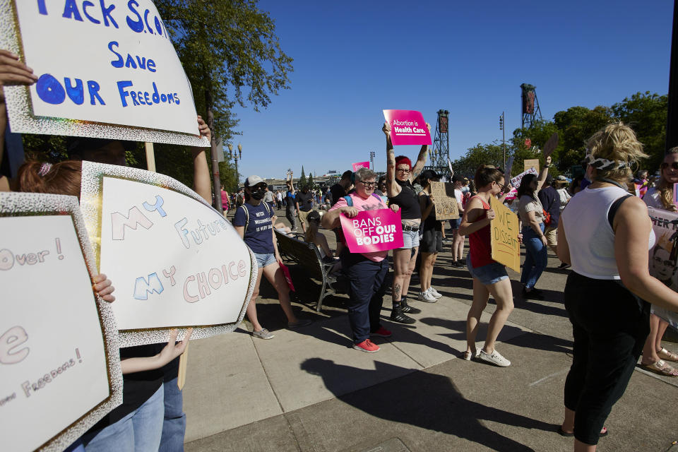 FILE - Protesters hold signs protesting against the Supreme Court's decision to overturn Roe v. Wade in Portland, Ore., Friday, June 24, 2022. Some abortion providers serving rural Western communities in states like Oregon where abortion remains legal worry access could be a challenge as more patients travel to their clinics from states where the procedure is banned or greatly restricted. (AP Photo/Craig Mitchelldyer, File)