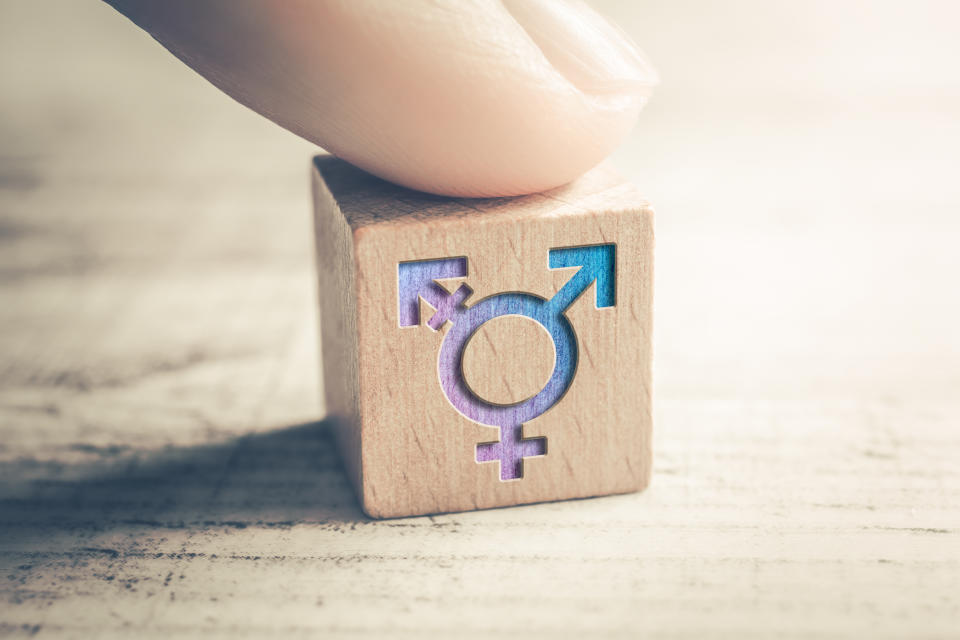 Transgender, LGBT or Intersex Icon On Wodden Block On A Table Arranged By A Finger