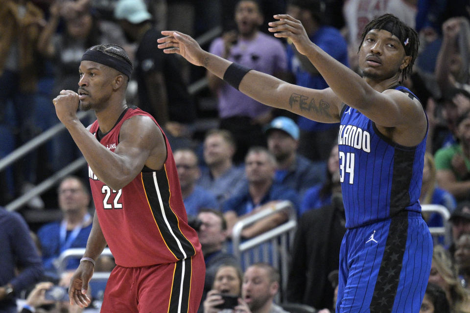 Miami Heat forward Jimmy Butler (22) and Orlando Magic center Wendell Carter Jr. (34) react after Butler scored a 3-point basket as time expired to send an NBA basketball game into overtime Saturday, March 11, 2023, in Orlando, Fla. (AP Photo/Phelan M. Ebenhack)