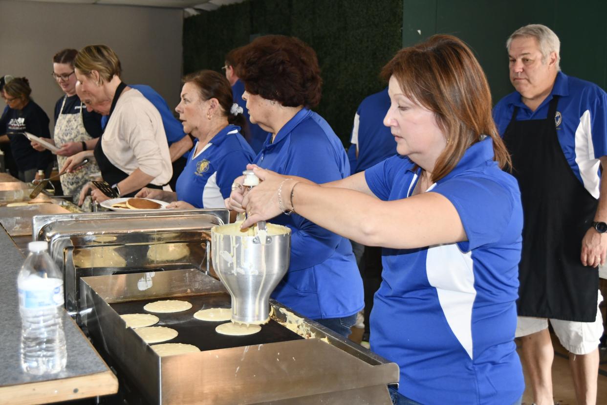 Members of the Fremont Kiwanis Club cook pancakes on the griddle on Wednesday, during the 63rd Annual Pancake Festival held at Victor's Banquet Hall.