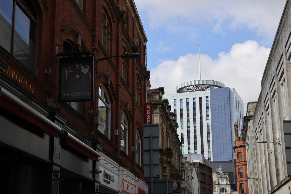 A dark street leading to a high-rise building