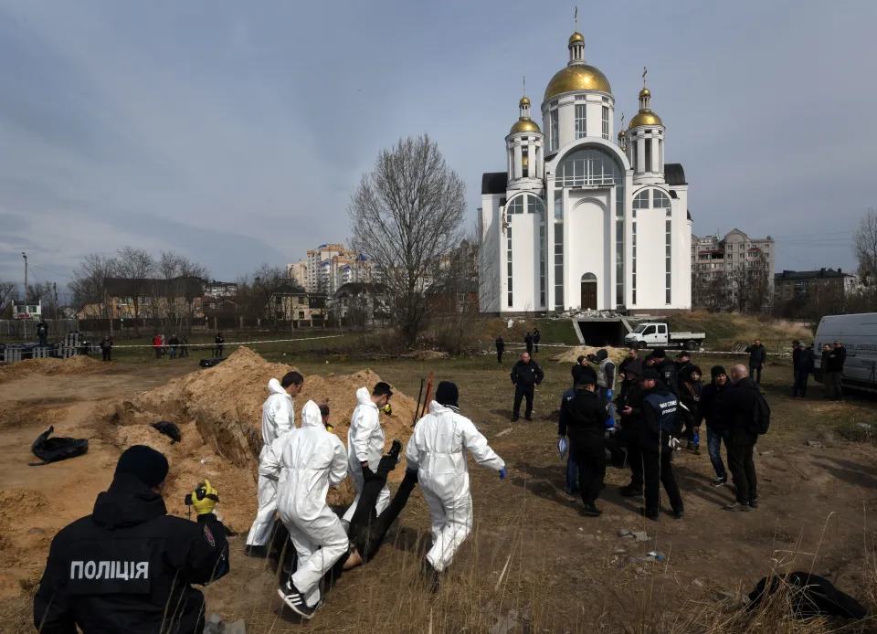 Investigators pull bodies from a mass grave near the Church of St. Andrew and All Saints in Bucha.