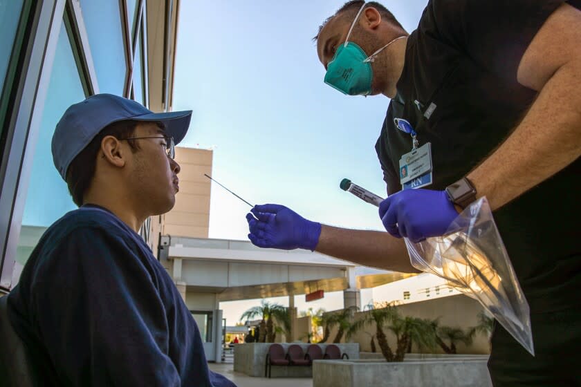 Jeffrey Toth, RN, administers a coronavirus PCR test