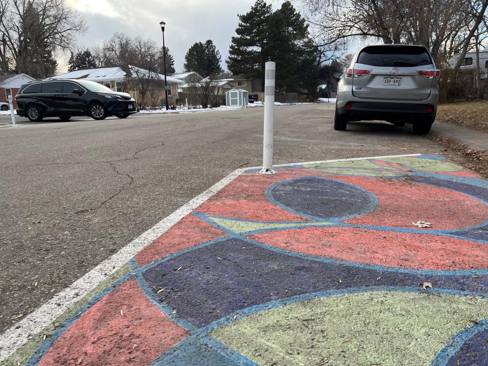An asphalt art project at Maple Street and Roosevelt Avenue in northwest Fort Collins extends the curb through paint and pylons to give pedestrians greater visibility and cue drivers to slow down.