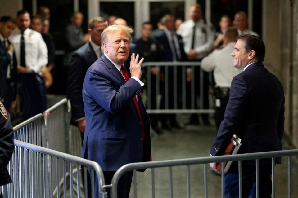 Donald Trump gestures outside the courtroom on the day of a court hearing on charges of falsifying business records (REUTERS)