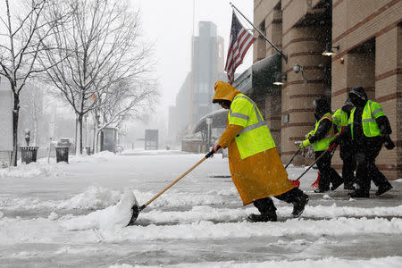 Workers clear a street during a snowstorm in Washington, U.S., March 21, 2018. REUTERS/Yuri Gripas