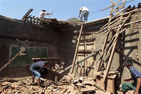 Residents of Nagarote town repair the roof of their house that was damaged in Thursday's earthquake, in Nagarote April 12, 2014. REUTERS/Oswaldo Rivas